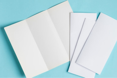 Brochures en blanco sobre una superficie azul.