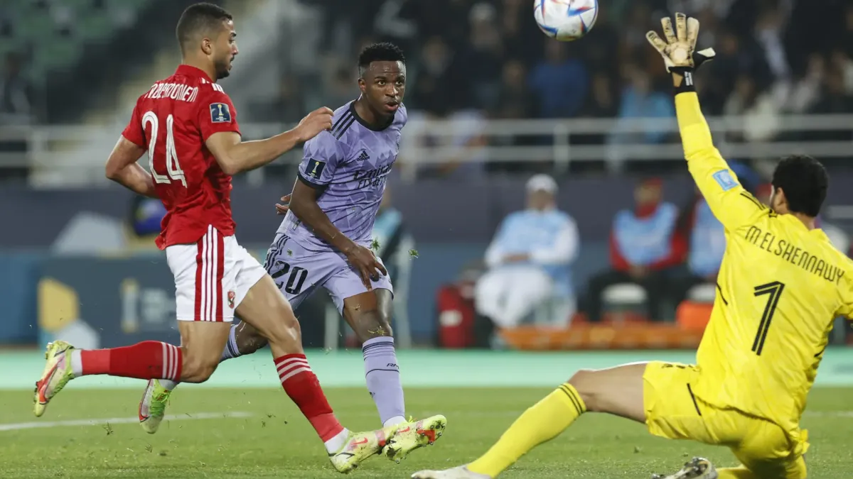 El delantero brasileño del Real Madrid Vinícius Jr (c) remata ante el guardameta del Al Ahly, el egipcio Mohamed El Shenawy (d), para conseguir el primer gol del equipo madridista durante el partido correspondiente a las semifinales del Mundial de Clubes entre el Al Ahly y el Real Madrid, este miércoles en Rabat.