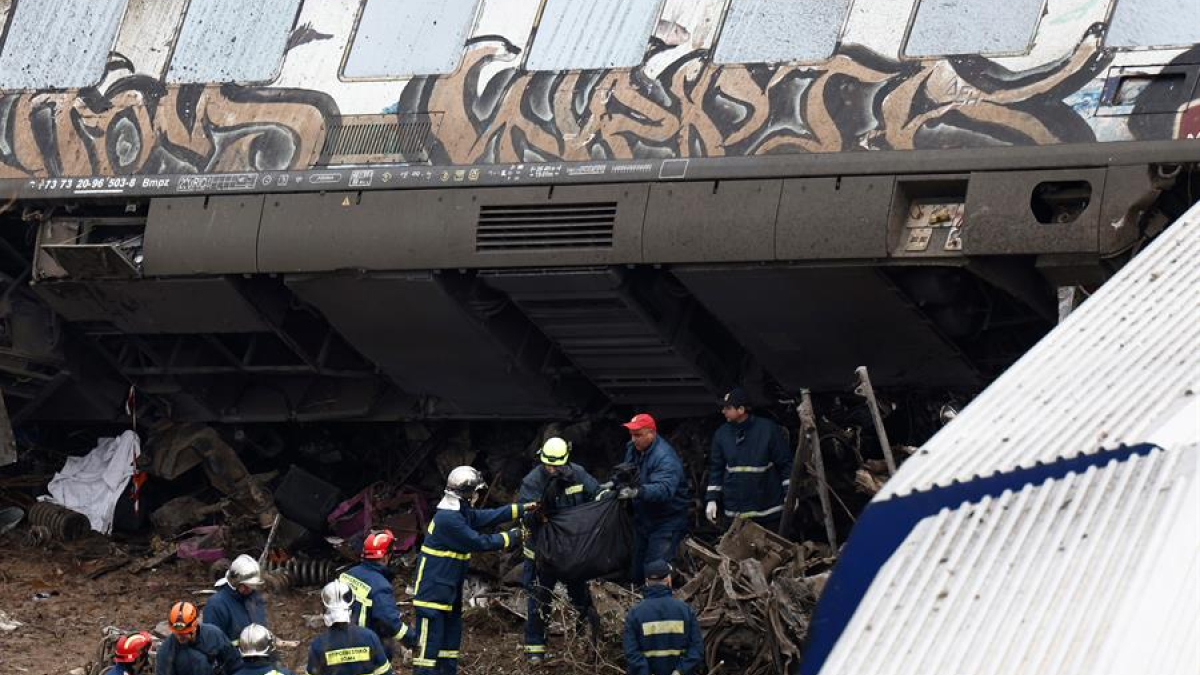Los bomberos trabajan en el lugar del choque de dos trenes ocurrido anoche al norte de Larissa, en Grecia central