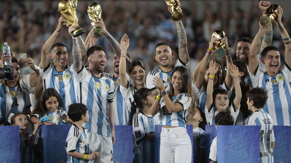 Lionel Messi (adelante, a la izquierda), acompañado de su esposa Antonela Roccuzzo y sus hijos, encabezó la celebración argentina, en la que los jugadores levantaron el trofeo de la Copa Mundo ante su hinchada, en la primera presentación de la Selección como tricampeona tras la obtención del título en Qatar 2022.