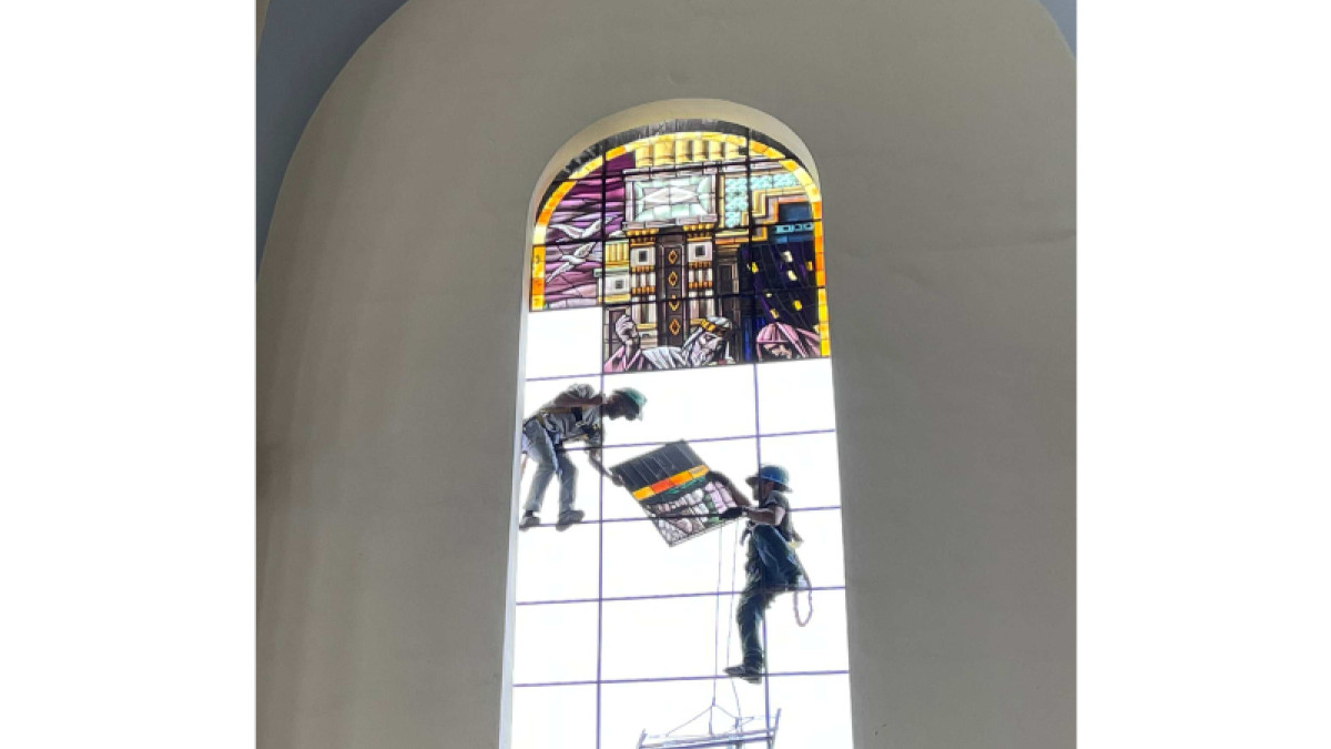 Esta perspectiva permite dimensionar el tamaño del vitral comparado con las personas que los desmontan con sumo cuidado.