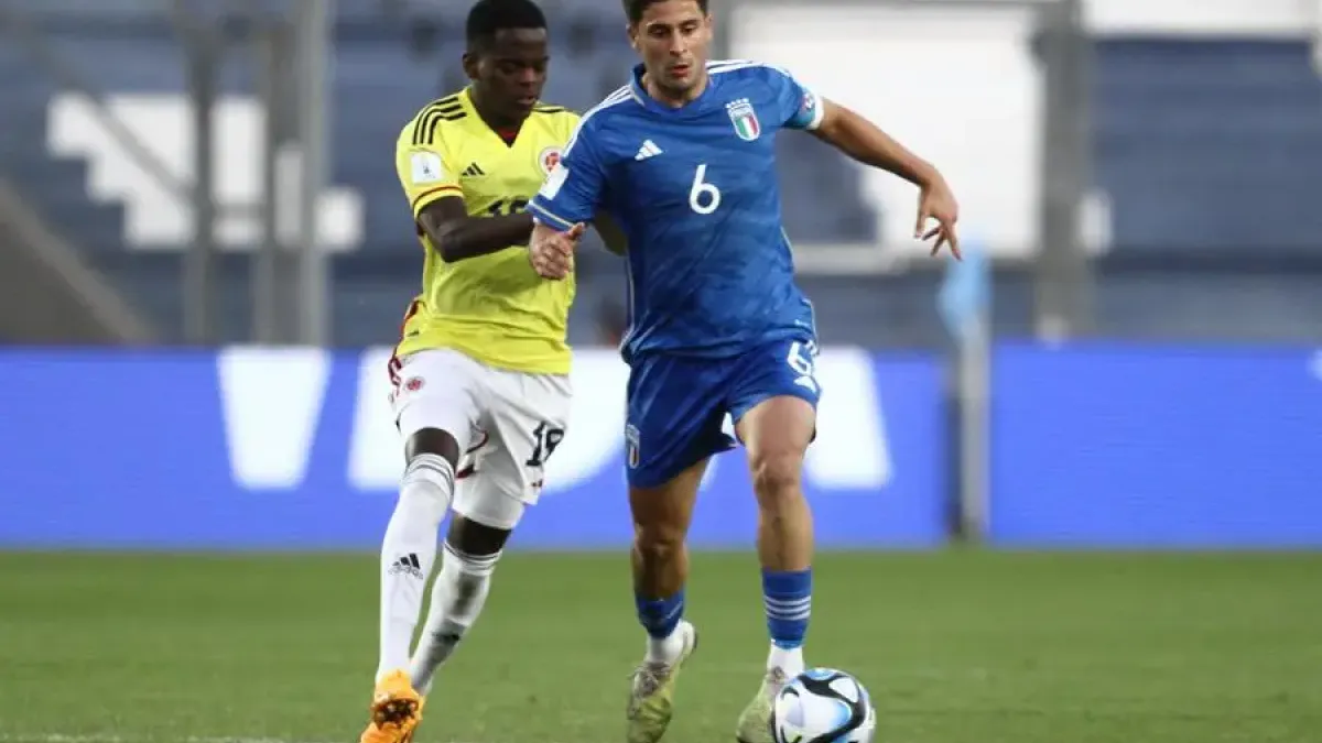 Miguel Monsalve (i) de Colombia disputa un balón con Samuel Giovane de Italia
