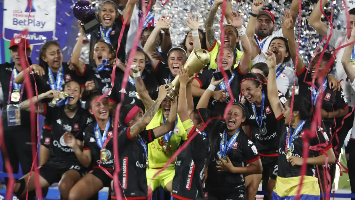 Jugadoras de Santa Fe celebran con el trofeo al ganar la final de la Liga Profesional femenina ante el América en el estadio Pascual Guerrero en Cali.