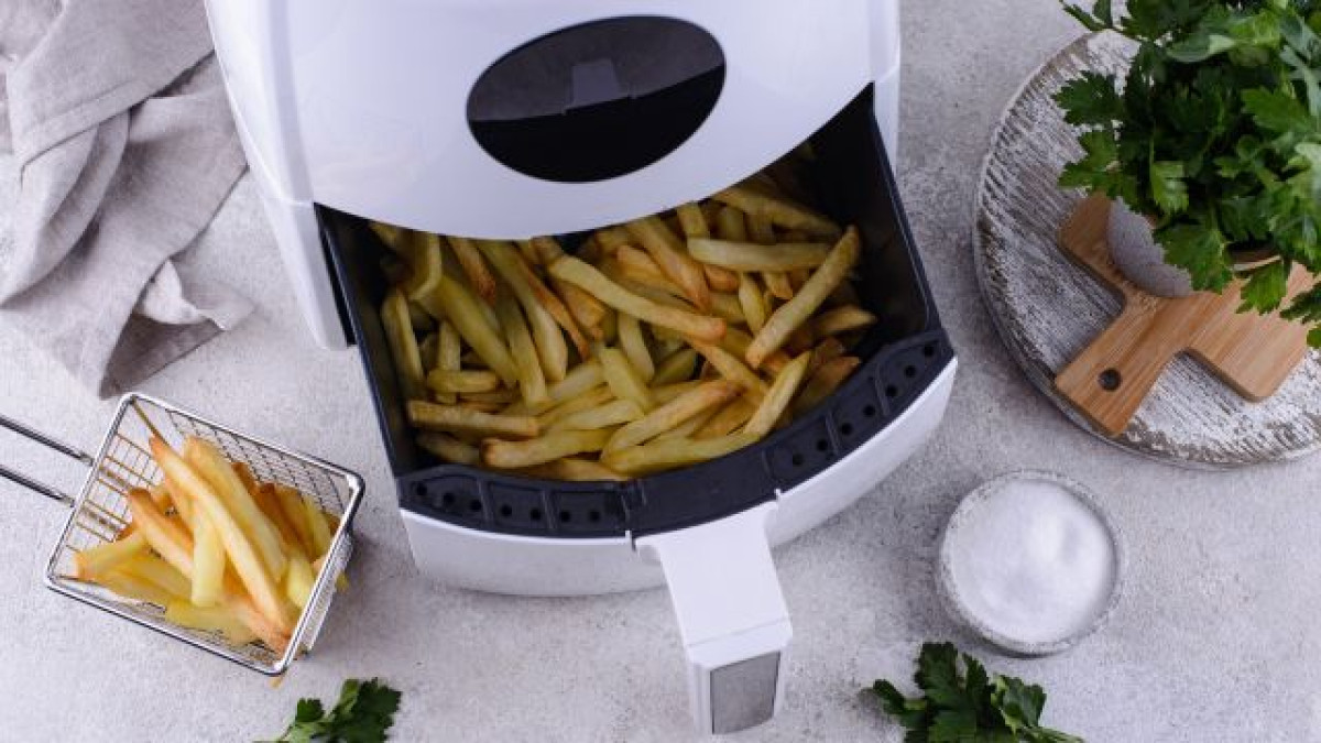Freidora de aire abierta con papas fritas adentro.