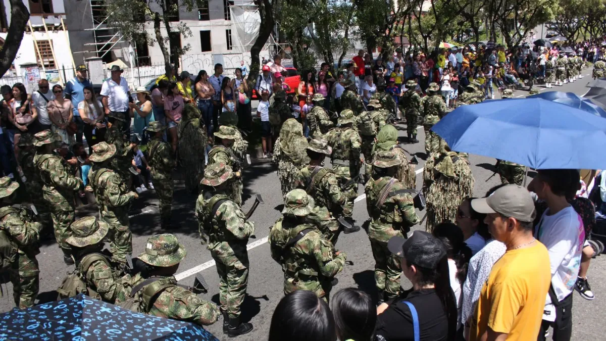 Las familias esperaron con paciencia y alegría el paso del desfile de Conmemoración de los 213 años de Independencia de Colombia. Muchas se refugiaron en sus sombrillas para aguantar el intenso verano que al mediodía marcaba los 24 grados centígrados.