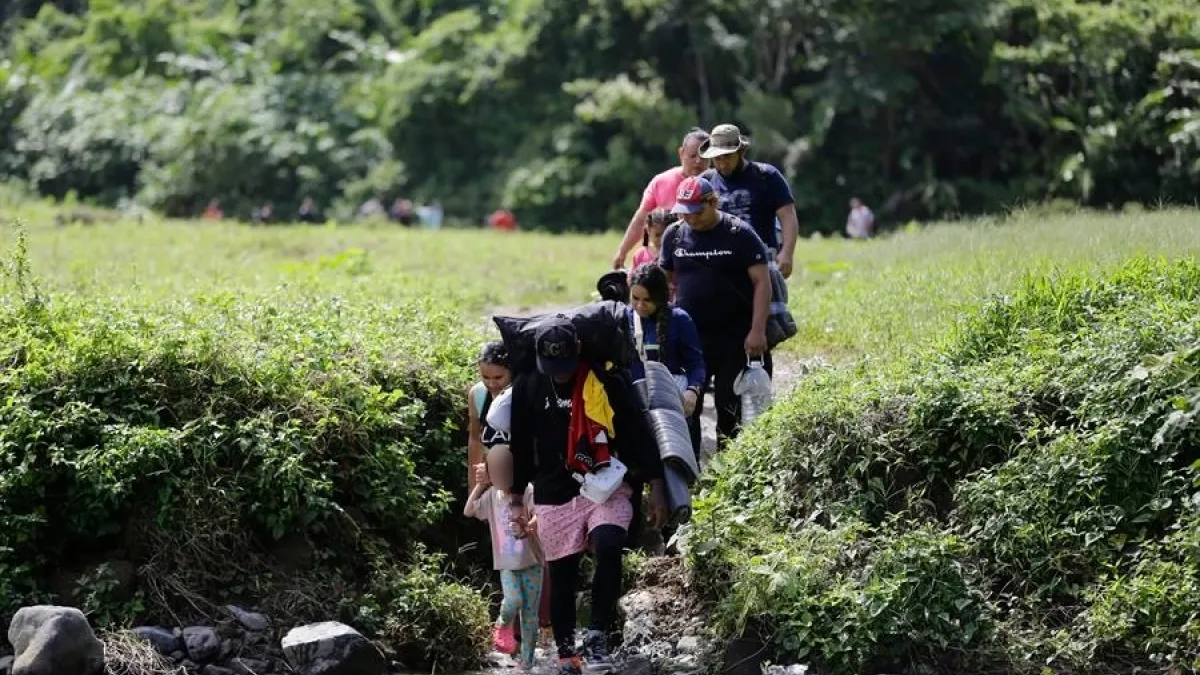Una familia de migrantes camina en el sector de Cañas Blancas en el Darién (Panamá). Una media de 2.500 migrantes llegan cada día a Panamá en su viaje hacia Norteamérica tras cruzar la inhóspita jungla del Darién, en la frontera con Colombia.