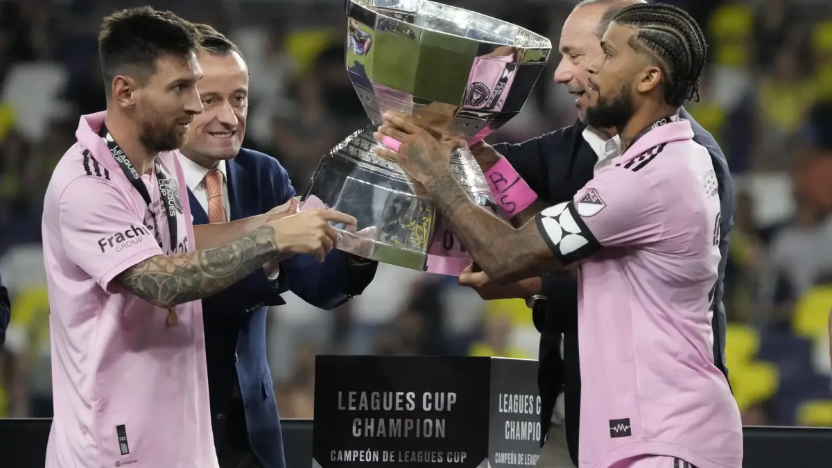 El delantero de Inter Miami CF Lionel Messi (i) y el defensor DeAndre Yedlin (d) reciben el trofeo de su equipo después de vencer a Nashville SC en la final de la Copa de las Ligas 2023 en Geodis Park en Nashville, Tennessee, EE. UU.
