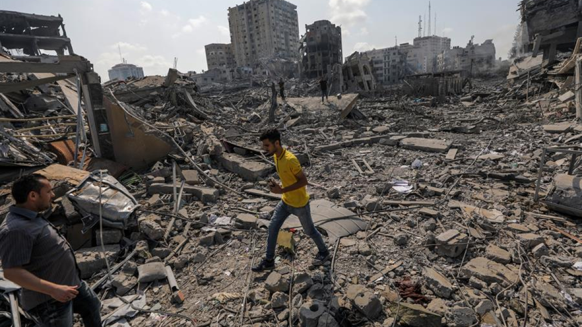 Palestinos caminan entre los escombros tras un ataque a la zona de Al-Ramal, tras un ataque israelí, este martes en la Ciudad de Gaza.