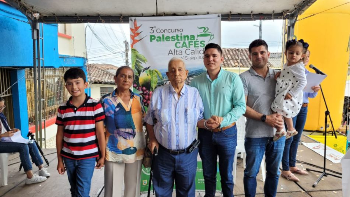 Los tres primeros puestos de Palestina. De izquierda a derecha, Luz Estella Gutiérrez (2.ª), José Gildardo Mejía (3.º, de camisa de rayas) y Hernán Mauricio Guzmán (1.º, con la niña en brazos).
