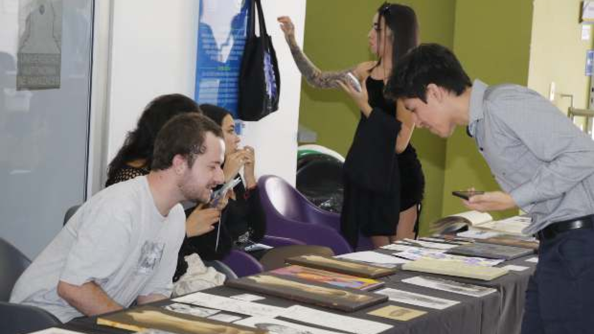 Manuel Alejandro Pinilla (derecha), docente de Diseño y Arte de la UAM, da un vistazo a los trabajos de su púpilos de las uniersidades de la ciudad.
