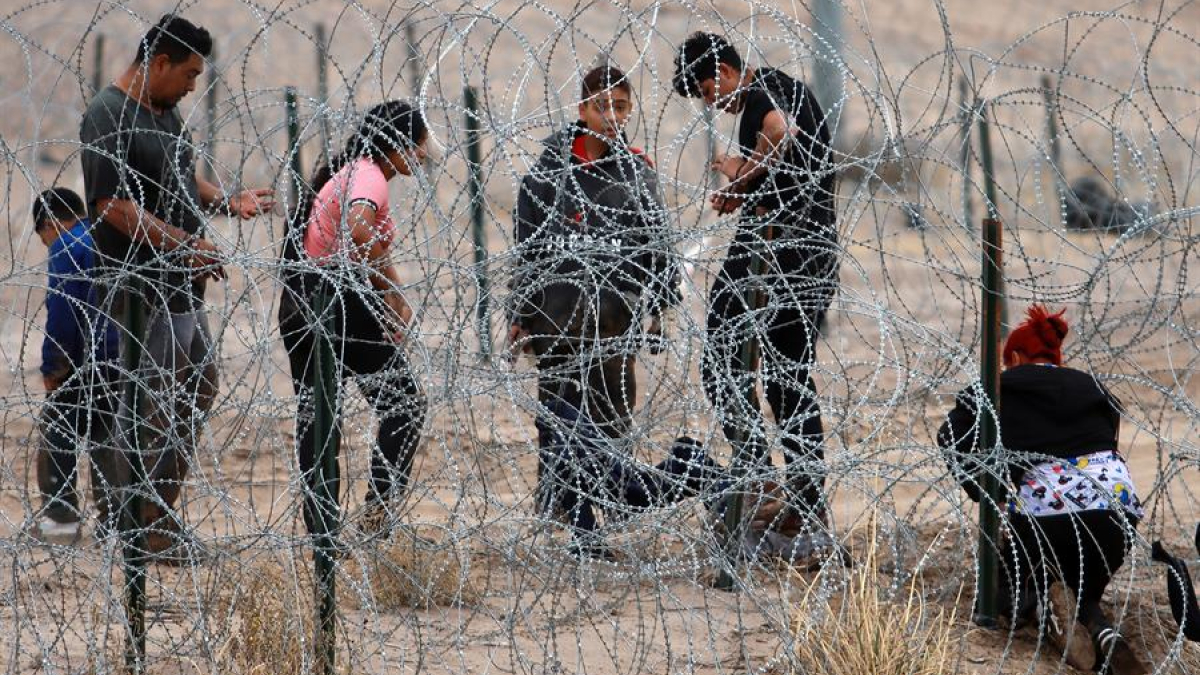AutoridadeMigrantes intentan cruzar la cerca de alambres en la frontera que divide a México de los Estados Unidos, en Ciudad Juárez (México).s y activistas