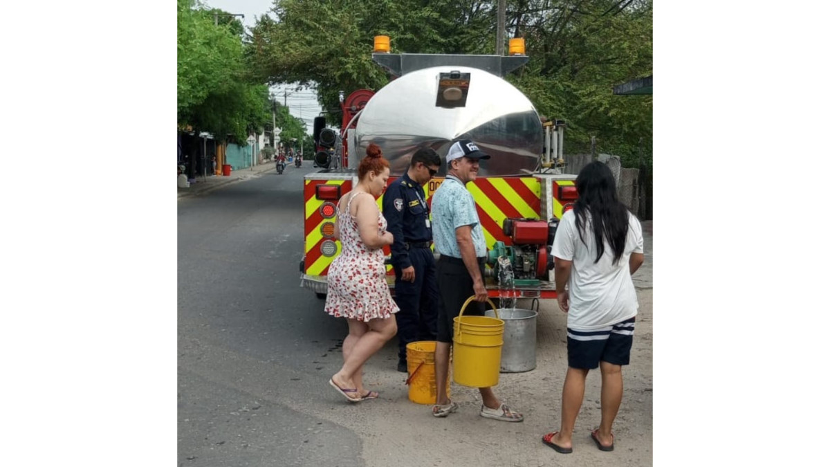 Los ciudadanos con baldes de diversos tamaños arriban al carro de Bomberos para suministrarse de agua.