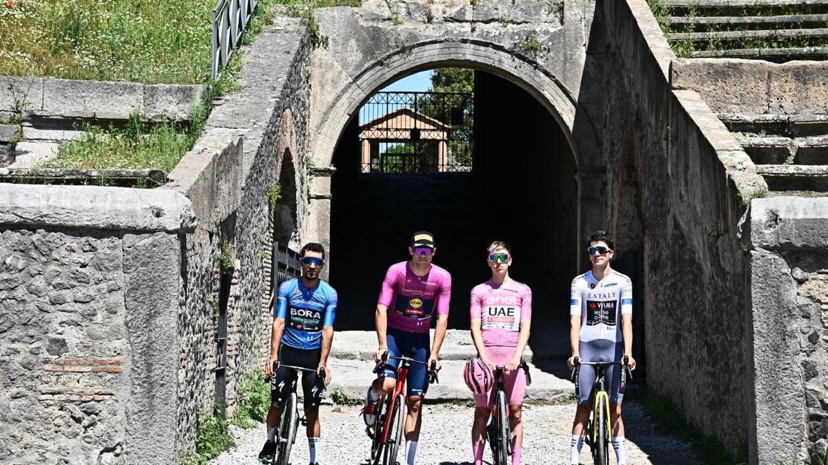 De izquierda a derecha, el ciclista colombiano Daniel Felipe Martínez con el maillot azul del mejor escalador (Martínez es segundo en ese ranking, Pogacar primero), Jonathan Milan con el maillot malva del líder en la clasificación por puntos, Tadej Pogacar con la maglia rosa de líder general y Cian Uijtdebroeks con la camiseta blanca del mejor joven ciclista posaron para fotos en el anfiteatro de Pompeya antes del inicio de la décima etapa del Giro de Italia, que ganó el francés Valentin Paret-Peintre.