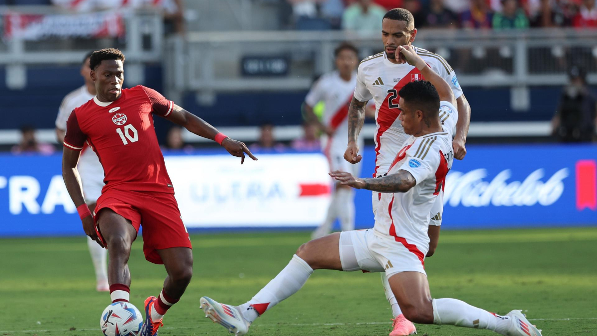 Jonathan David, de Canadá, disputa la pelota con el defensor de Perú, Anderson Santamaría. 
