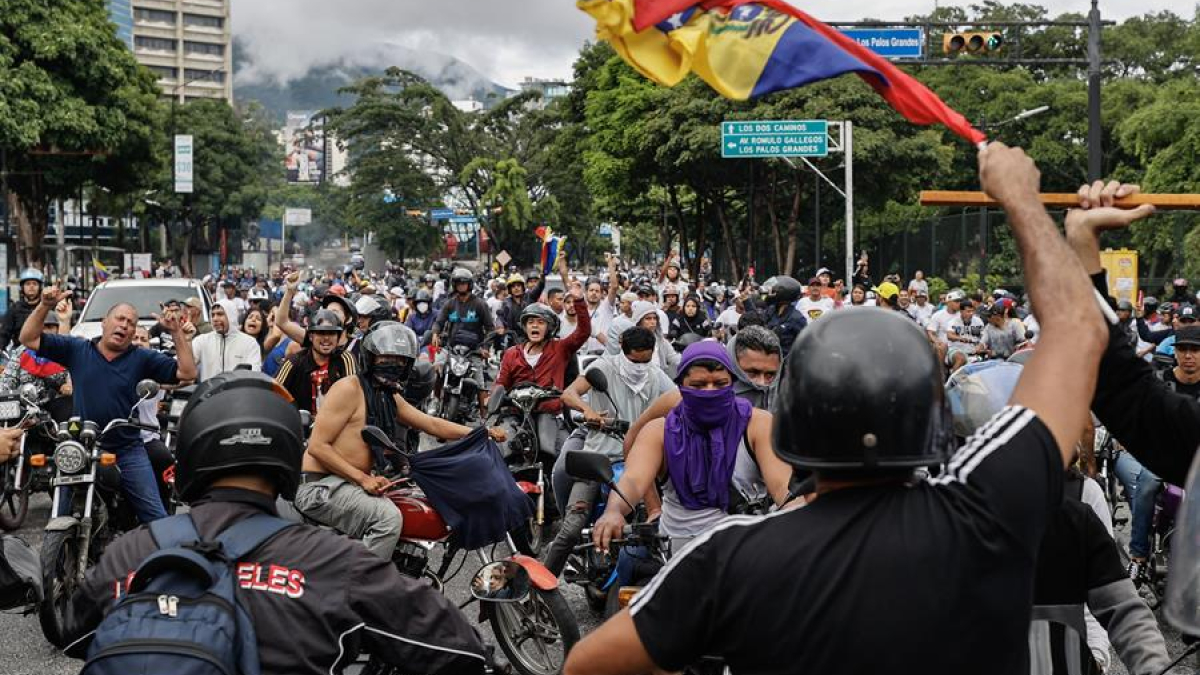 Personas recorren las calles en motocicletas durante una protesta por los resultados de las elecciones presidenciales este lunes, en Caracas (Venezuela). 