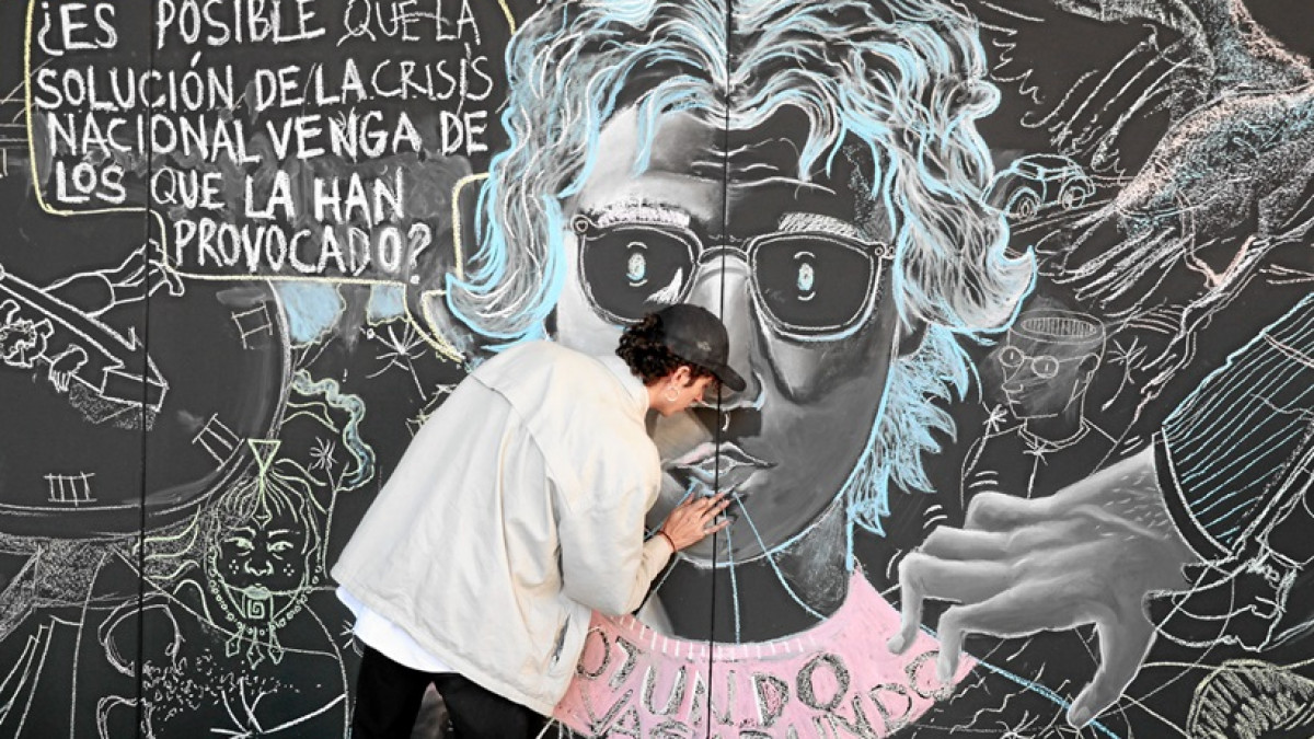 El artista Sergio Antonio Palacio Montoya dibuja un mural con el rostro del periodista y humorista asesinado Jaime Garzón, durante el acto conmemorativo en Bogotá.
