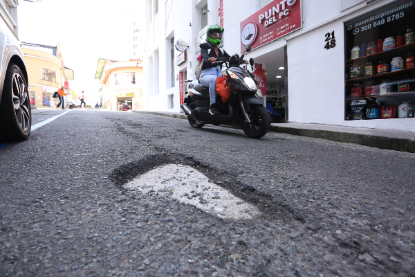 Son tres huecos los que acompañan el tramo de la vía haciendo saltar a carros y motos. Un cuidador de vehiculos dice que el daño lleva por lo menos cuatro años.