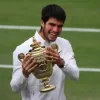 Carlos Alcaraz de España celebra con su trofeo después de ganar su último partido individual masculino contra Novak Djokovic de Serbia en el Campeonato de Wimbledon, en Gran Bretaña.