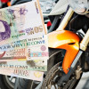 Consultar-impuestos-de-moto-por-placa Mano sosteniendo billetes de pesos colombianos frente a varias motos.