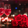 Cuando-es-san-valentin-en-colombia Copas con vino rosado al lado de rosas rojas.