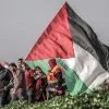 Varios palestinos portan una bandera.