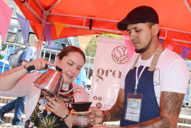 "El amor que depositan los caficultores en el grano debemos representarlo también como baristas y catadores", afirma Viviana Grand, quien atiende a los visitantes de la Feria de Café, Cultura y Tradición en el estand de Grand Coffee Shop, de Villamaría (Caldas), junto a Juan Federico Palacio.