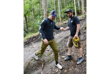 Jorge Mario Jaramillo, 'Chigüiro' (derecha), le ayuda al francés Loïc Bruni para que no se resbale sobre la pista en la que se correrá desde hoy el Downhill de las Flores.