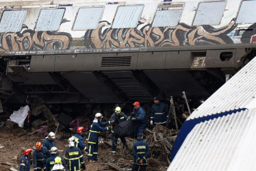 Los bomberos trabajan en el lugar del choque de dos trenes ocurrido anoche al norte de Larissa, en Grecia central