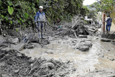 Foto | EFE | LA PATRIA  Con un mar de lodo hasta las rodillas y entre muebles y vehículos arrastrados por el barro, familiares de las víctimas de la avalancha que arrasó el caserío de Naranjal, en el pueblo de Quetame, buscan desesperadamente a los desaparecidos con la esperanza de encontrarlos vivos.