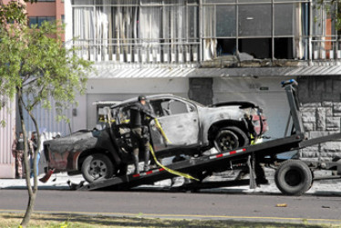 Foto | EFE | LA PATRIA  Un policía carga en una grúa los restos de un carro bomba que explotó en la madrugada de ayer en los exteriores del edificio del Servicio Nacional de Atención Integral a Personas Privadas de Libertad (SNAI), en Quito (Ecuador).