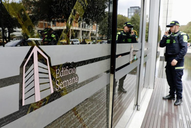 Un integrante de la Policía ayer afuera del edificio donde funciona la revista Semana, en Bogotá.