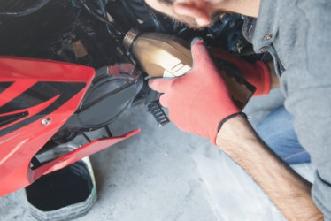 Persona cambiando el aceite de una moto.