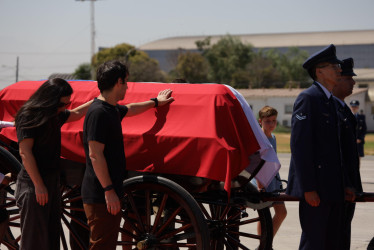 Familiares acompañan el féretro del expresidente Sebastián Piñera tras su arribo en un avión de la Fuerza Aérea de Chile al aeropuerto de Santiago.