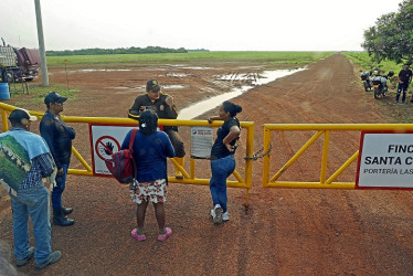 Foto | EFE | LA PATRIA  Indígenas sikuanis hablan con un vigilante en la finca Santa Clara, propiedad de la empresa cárnica La Fazenda, para que les permitan llegar a sus resguardos pero no se los permiten, en Puerto Gaitán (Meta).