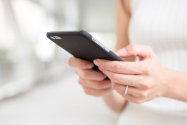 Mujer sosteniendo su teléfono celular.