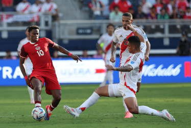 Jonathan David, de Canadá, disputa la pelota con el defensor de Perú, Anderson Santamaría. 