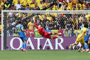 Nicolae Stanciu de Rumanía (d) anota el 1-0 contra el portero Andriy Lunin (c) de Ucrania durante el partido de fútbol del Grupo E de la Eurocopa 2024 entre Rumanía y Ucrania, en Munich, Alemania.