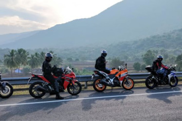 Personas montanto en moto en una carretera en la naturaleza.