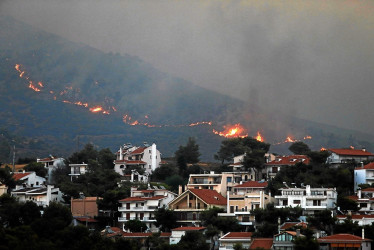 Un incendio se acercaba anoche a las casas en el monte Penteli, en el noreste de Grecia.