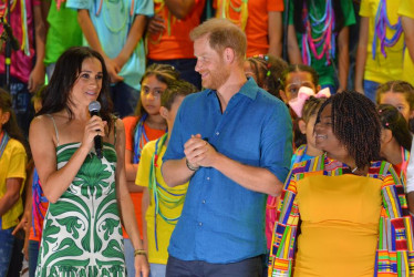 Los duques de Sussex Harry (c) y Meghan (i) junto a la vicepresidenta Francia Maquez, durante el cierre del Festival Petronio Álvarez, este domingo en Cali.