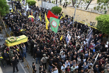 Dolientes llevan el ataúd de una de las personas que murieron este martes en explosiones de buscapersonas, durante la procesión fúnebre en el suburbio sur de Beirut.