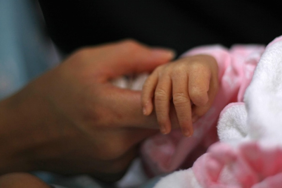 Ilustración de hombre sosteniendo la mano de un bebé.