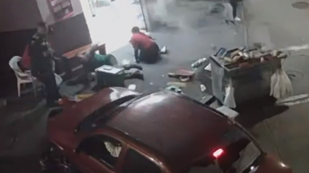 En una cámara de seguridad quedó registrado el momento en el que un carro chocó un puesto de comidas rápidas y lesionó a una persona. 